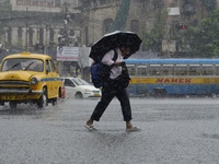 Commuters are walking past during rainfall in Kolkata, India, on July 08, 2024. (