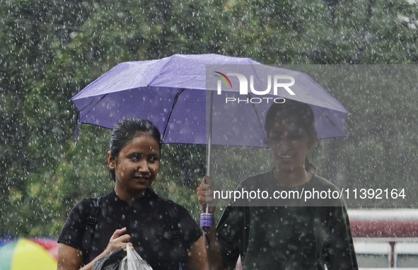 Commuters are walking past during rainfall in Kolkata, India, on July 08, 2024. 