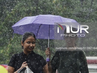 Commuters are walking past during rainfall in Kolkata, India, on July 08, 2024. (