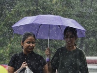 Commuters are walking past during rainfall in Kolkata, India, on July 08, 2024. (