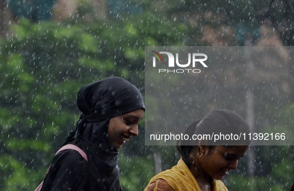 Commuters are walking past during rainfall in Kolkata, India, on July 08, 2024. 