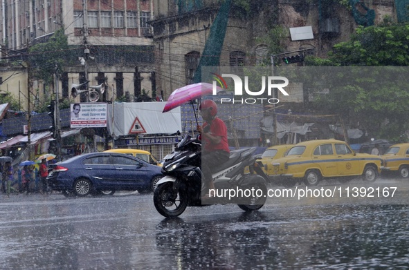 Commuters are walking past during rainfall in Kolkata, India, on July 08, 2024. 