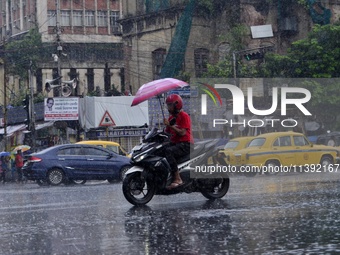 Commuters are walking past during rainfall in Kolkata, India, on July 08, 2024. (