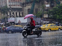 Commuters are walking past during rainfall in Kolkata, India, on July 08, 2024. (