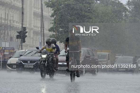 Commuters are walking past during rainfall in Kolkata, India, on July 08, 2024. 