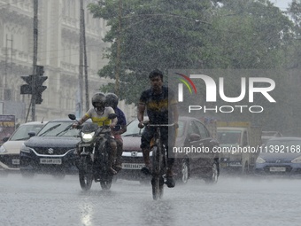 Commuters are walking past during rainfall in Kolkata, India, on July 08, 2024. (