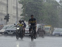 Commuters are walking past during rainfall in Kolkata, India, on July 08, 2024. (