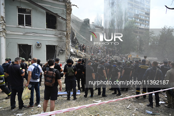 Ukrainian rescuers of emergency services and police officers are working at the site of Okhmatdyt children's hospital damaged by Russian mis...