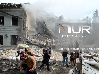 Ukrainian rescuers of emergency services and police officers are working at the site of Okhmatdyt children's hospital damaged by Russian mis...