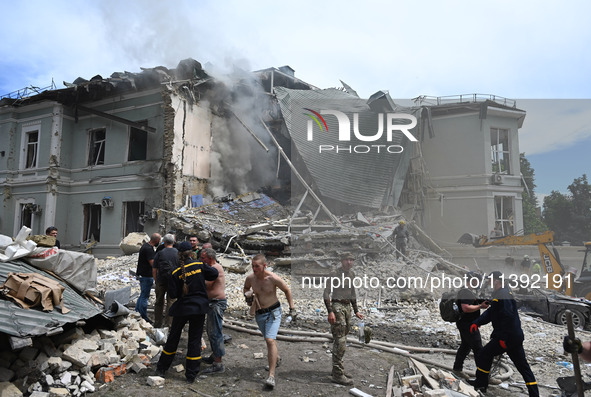 Ukrainian rescuers of emergency services and police officers are working at the site of Okhmatdyt children's hospital damaged by Russian mis...