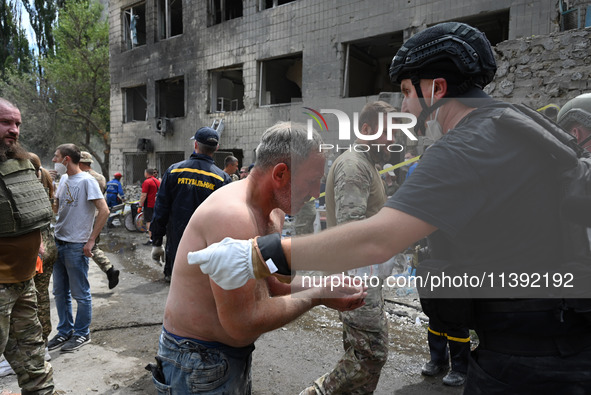 Ukrainian rescuers of emergency services and police officers are working at the site of Okhmatdyt children's hospital damaged by Russian mis...