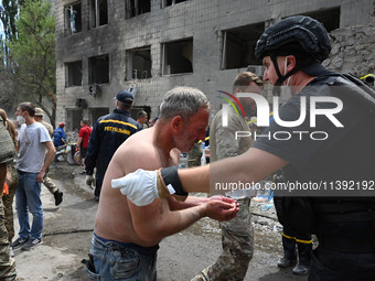 Ukrainian rescuers of emergency services and police officers are working at the site of Okhmatdyt children's hospital damaged by Russian mis...