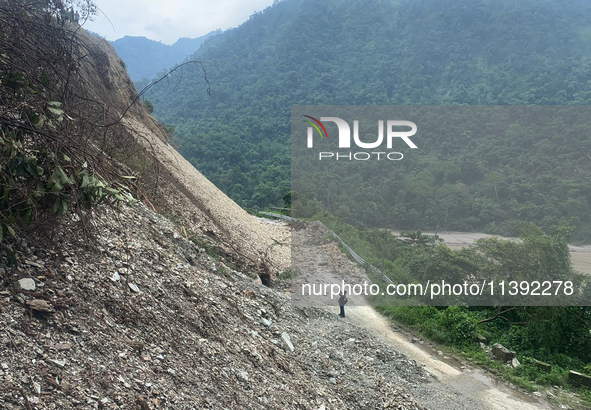 Workers are using excavators to clear a landslide along the national highway 10 that connects Sikkim and West Bengal states in Sevok, some 3...