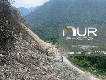 Workers are using excavators to clear a landslide along the national highway 10 that connects Sikkim and West Bengal states in Sevok, some 3...