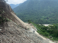 Workers are using excavators to clear a landslide along the national highway 10 that connects Sikkim and West Bengal states in Sevok, some 3...