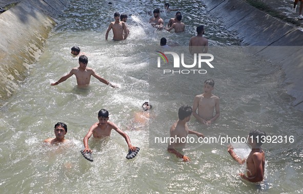 Boys are cooling themselves off on a hot summer day on the outskirts of Srinagar, Kashmir, on July 08, 2024. According to the weather depart...