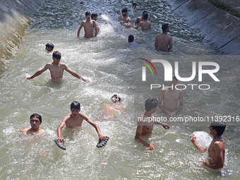 Boys are cooling themselves off on a hot summer day on the outskirts of Srinagar, Kashmir, on July 08, 2024. According to the weather depart...