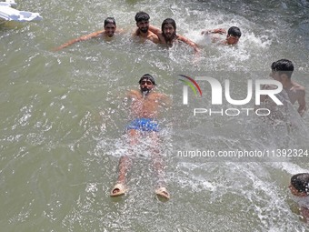 Boys are cooling themselves off on a hot summer day on the outskirts of Srinagar, Kashmir, on July 08, 2024. According to the weather depart...