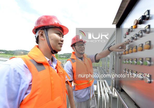 Workers are inspecting water supply equipment in Chaohu, China, on July 8, 2024. 