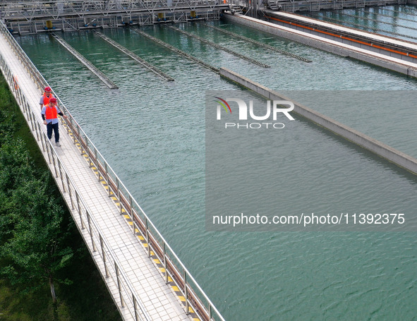 Workers are inspecting a reaction sedimentation tank at a water plant in Chaohu city, Anhui province, China, on July 8, 2024. 