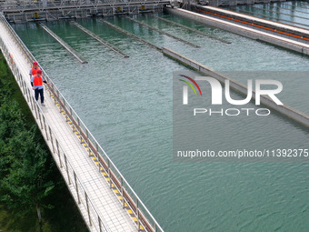 Workers are inspecting a reaction sedimentation tank at a water plant in Chaohu city, Anhui province, China, on July 8, 2024. (