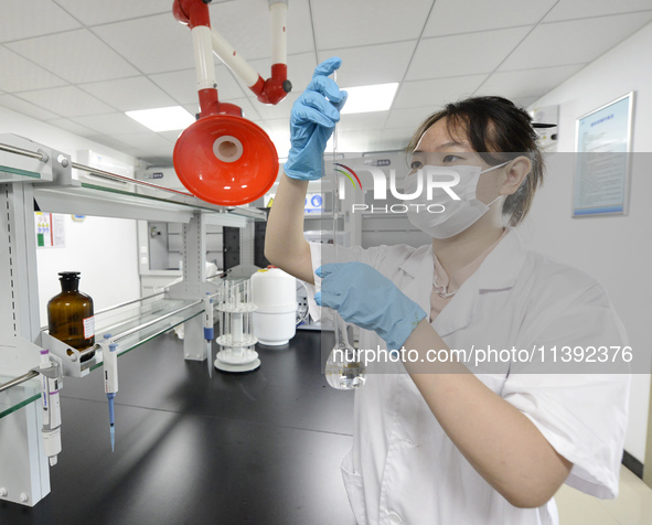 A worker is testing the water quality in Chaohu, China, on July 8, 2024. 