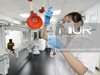 A worker is testing the water quality in Chaohu, China, on July 8, 2024. (