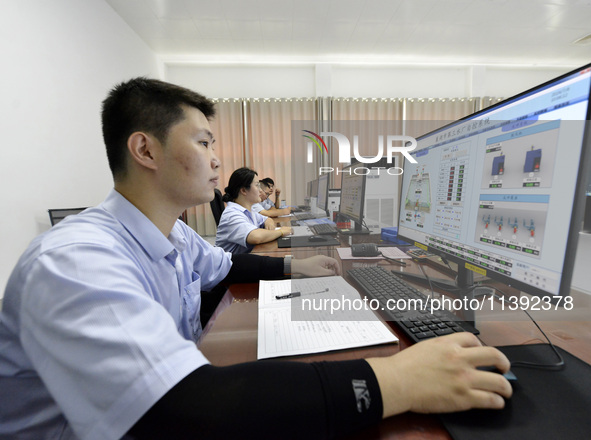 Workers are monitoring the operation of water supply equipment in the central control room of a water plant in Chaohu, China, on July 8, 202...