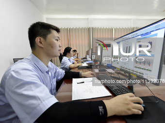 Workers are monitoring the operation of water supply equipment in the central control room of a water plant in Chaohu, China, on July 8, 202...