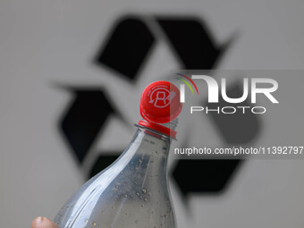 A plastic soda bottle with an attached cap (tethered cap) is being shown as per new EU regulations in Brussels, Belgium, on July 8, 2024. (