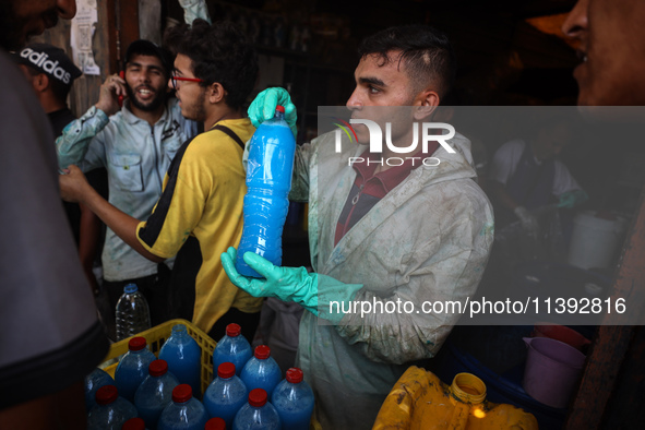 Palestinian manufacturers are bottling locally-made cleaning products in Deir el-Balah in the central Gaza Strip on July 8, 2024, amid a lac...