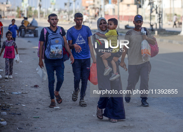 Displaced Palestinians are fleeing from the Al-Rimal neighborhood and Al-Sabra in Gaza City and are walking along Salah al-Din Street as the...