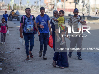 Displaced Palestinians are fleeing from the Al-Rimal neighborhood and Al-Sabra in Gaza City and are walking along Salah al-Din Street as the...