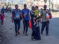 Displaced Palestinians are fleeing from the Al-Rimal neighborhood and Al-Sabra in Gaza City and are walking along Salah al-Din Street as the...