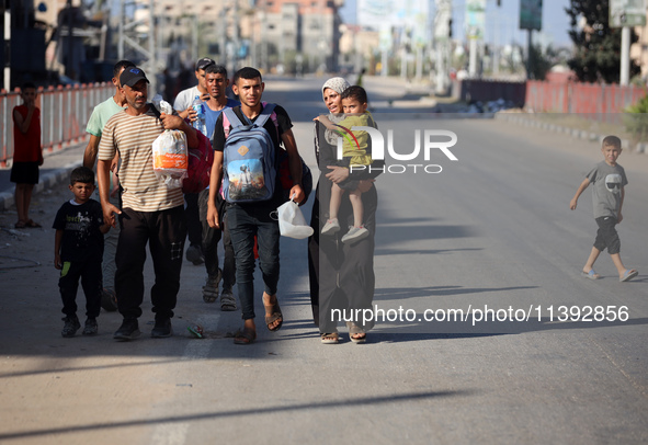 Displaced Palestinians are fleeing from the Al-Rimal neighborhood and Al-Sabra in Gaza City and are walking along Salah al-Din Street as the...