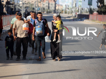 Displaced Palestinians are fleeing from the Al-Rimal neighborhood and Al-Sabra in Gaza City and are walking along Salah al-Din Street as the...