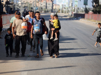 Displaced Palestinians are fleeing from the Al-Rimal neighborhood and Al-Sabra in Gaza City and are walking along Salah al-Din Street as the...