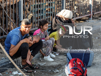 Displaced Palestinians are fleeing from the Al-Rimal neighborhood and Al-Sabra in Gaza City and are walking along Salah al-Din Street as the...