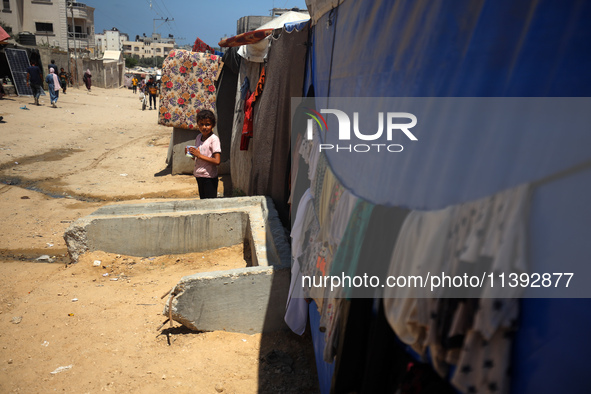 A displaced Palestinian girl is standing in front of her tent in Deir al-Balah in the central Gaza Strip on July 8, 2024, amid the ongoing c...