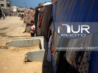 A displaced Palestinian girl is standing in front of her tent in Deir al-Balah in the central Gaza Strip on July 8, 2024, amid the ongoing c...