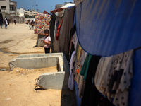 A displaced Palestinian girl is standing in front of her tent in Deir al-Balah in the central Gaza Strip on July 8, 2024, amid the ongoing c...