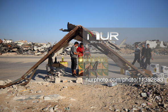 Palestinians are walking past cooking oil for sale along Salah al-Din Street in Deir el-Balah in the central Gaza Strip, on July 8, 2024, am...