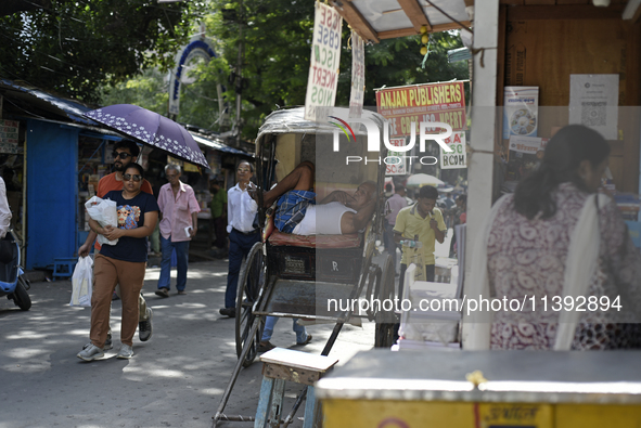 A rickshaw puller is relaxing on his rickshaw during the afternoon, in North Kolkata, India, on July 8, 2024. 