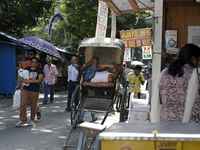 A rickshaw puller is relaxing on his rickshaw during the afternoon, in North Kolkata, India, on July 8, 2024. (