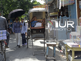 A rickshaw puller is relaxing on his rickshaw during the afternoon, in North Kolkata, India, on July 8, 2024. (