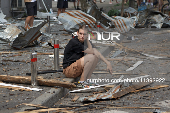 A young man is sitting on the curb among the debris near the Lukianivska metro station during a Russian missile attack in Kyiv, Ukraine, on...