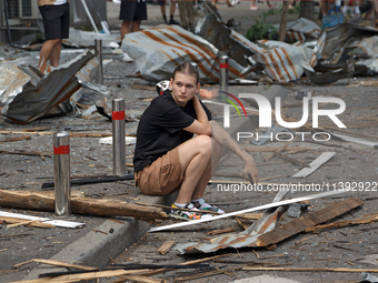 A young man is sitting on the curb among the debris near the Lukianivska metro station during a Russian missile attack in Kyiv, Ukraine, on...