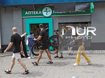 People are walking past a pharmacy with smashed windows near the Lukianivska metro station during a Russian missile attack in Kyiv, Ukraine,...