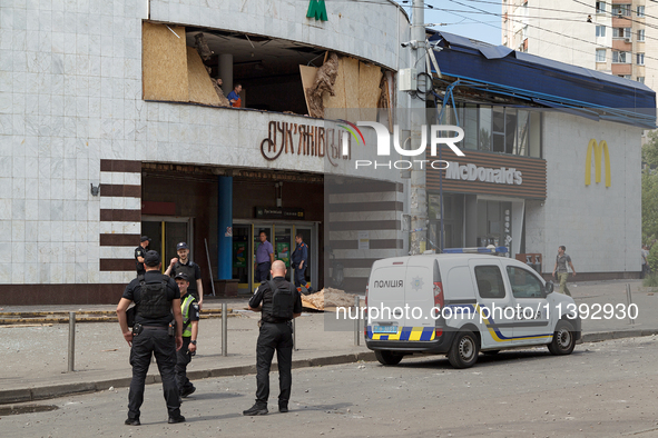 Police officers are standing outside the Lukianivska metro station damaged during a Russian missile attack in Kyiv, Ukraine, on July 8, 2024...