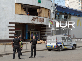 Police officers are standing outside the Lukianivska metro station damaged during a Russian missile attack in Kyiv, Ukraine, on July 8, 2024...